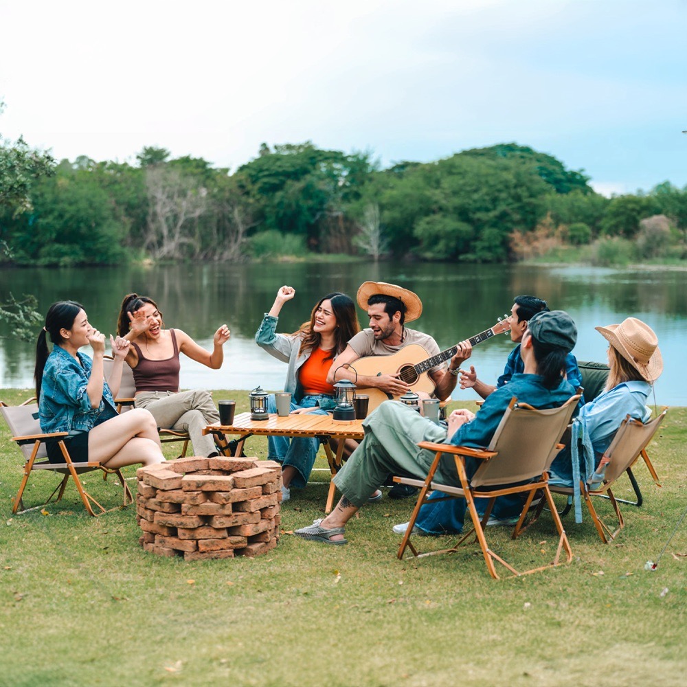 Colleagues singing around a campfire at a company retreat